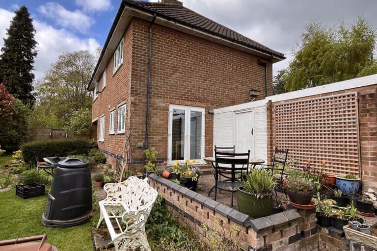 The rear of the red brick house in the Repton Conservation Area, with its garden and patio