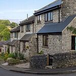 Stone cottages lining a village street with moorland rising behind