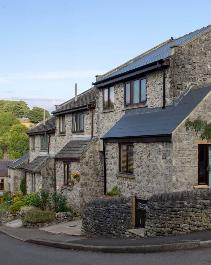 Stone cottages lining a village street with moorland rising behind