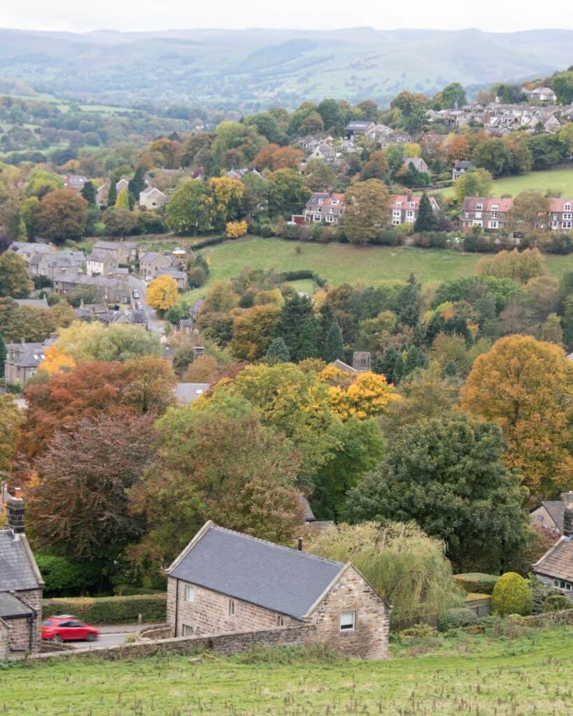 Stone houses and autumn trees at Hathersage, with the Peak District moors beyond